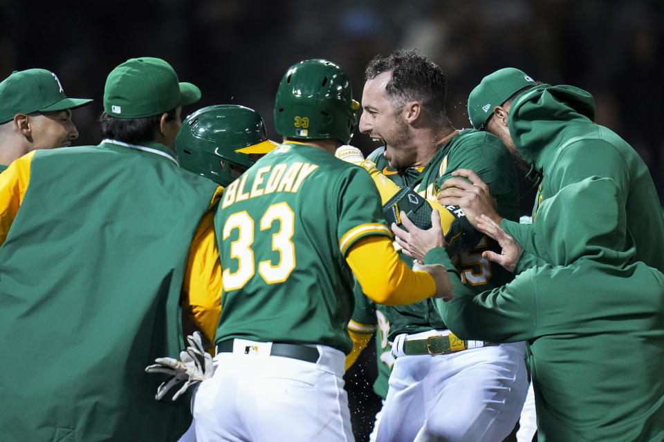 Oakland Athletics' Brent Rooker, center right, celebrates with teammates after hitting the game-winning, three-run home run against the Texas Rangers during the 10th inning of a baseball game in Oakland, Calif., Friday, May 12, 2023. (AP Photo/Godofredo A. Vásquez)