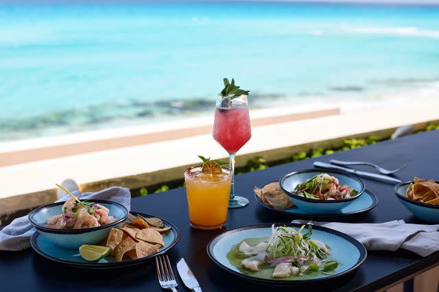 <p>Courtesy of Marriott Cancun, an All-Inclusive Resort</p> Cocktails and plates of food from the Cevicheria at the Marriott Cancun, an All-Inclusive Resort