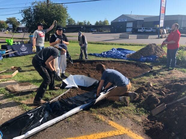 Volunteers help build a rain garden in front of Habitat for Humanity's office and ReStore in Thunder Bay, Ont. (Jeff Walters/CBC - image credit)