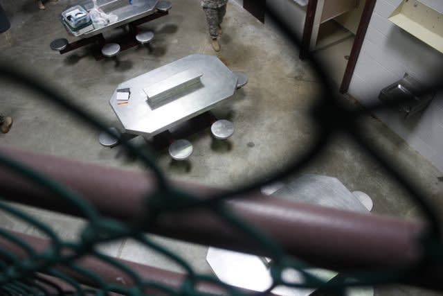 A cell block at Guantanamo's Camp VI that had been occupied until a raid on April 13, 2013. One detainee had written "stop tortur us. stop desclate our relgion" on the wall of his cell. The officer in charge of the facility said that detainees had hoarded all types of materials in the communal area.