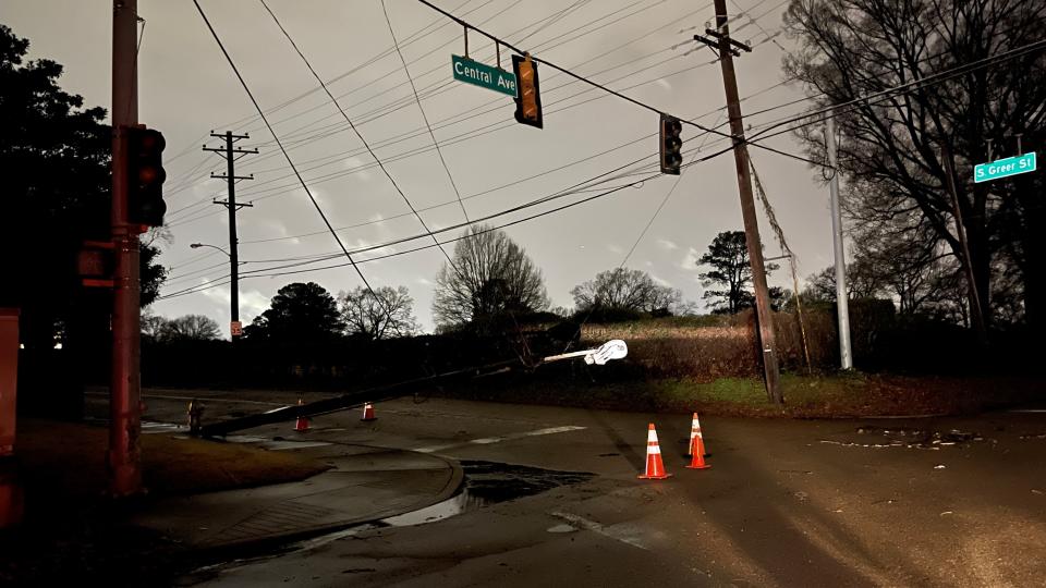 A light pole rests on power lines after falling at the intersection of Central Avenue at South Greer Street in East Memphis after storms moved through the area overnight on Saturday, Dec. 11, 2021.