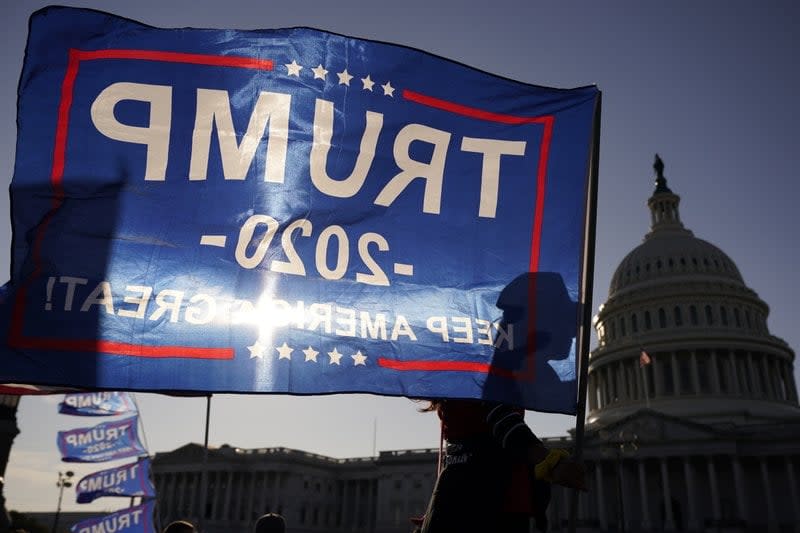 A supporter of President Donald Trump holds a Trump 2020 flag during a rally on Nov. 14, 2020, outside the U.S. Capitol building in Washington, D.C. (AP Photo/Jacquelyn Martin)