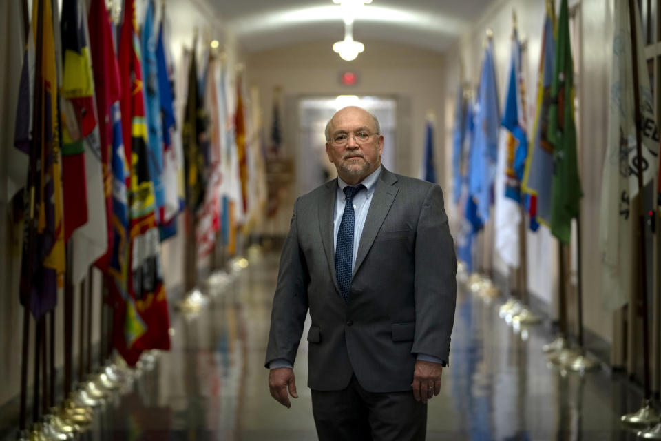 Tracy Toulou, the outgoing Director of the Office of Tribal Justice, stands in a hallway lined with flags of tribal nations at the Department of Justice, Thursday, March 14, 2024, in Washington. For more than two decades, Toulou has confronted the serious public safety challenges facing Indian Country by working to expand the power of tribal justice systems. Today, tribal law enforcement finally has a seat at the table when federal authorities coordinate with state and local police, according to the Justice Department’s point person on Native American tribes. (AP Photo/Mark Schiefelbein)