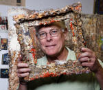 FILE - This Oct. 29, 2009 file photo shows Father Bill Moore with one of his pieces of art in his studio at the Pomona Arts Colony in Pomona, Calif. Father Bill Moore, a Catholic priest and prominent abstract expressionist who spent decades spreading spiritualism through his paintings, has died. He was 71. Longtime friend Tom Irwin says Moore died Sunday, Oct. 18, 2020 of prostate cancer. Seeing his artistic talent, Moore's Southern California parish, the Sacred Hearts of Jesus and Mary, allowed him to spend much of his time painting. (AP Photo/Damian Dovarganes, File)