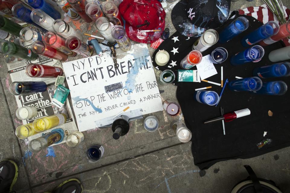 FILE - In this Saturday, July 19, 2014, file photo, a memorial for Eric Garner rests on the pavement near the site of his death, in the Staten Island borough of New York. In 2014, the world witnessed a New York police officer put Garner in a chokehold while arresting him for allegedly selling illegal cigarettes in Staten Island. The video, which would go on to set precedence for the documentation of police brutality, highlighted the use of a chokehold by the police department, which had banned the method in November 1993. But unlike in the aftermath of George Floyd's killing in 2020, little to no legislative change was spurred from Garner's death. (AP Photo/John Minchillo, File)