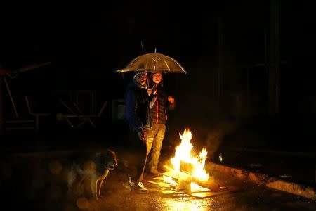 People gather around a bonfire during a blackout after an earthquake hit Chile's central zone, in Santiago, August 23, 2014. REUTERS/Ivan Alvarado