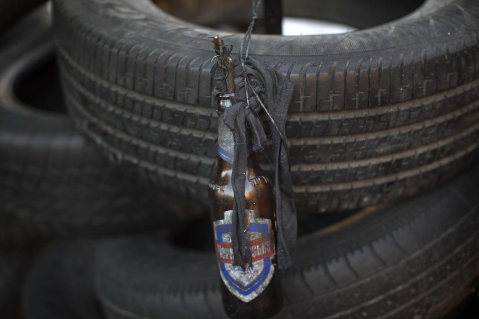 A molotov cocktail ready to be thrown hangs on a barricade heading to Kiev's Independence Square, the epicenter of the country's current unrest, Ukraine, Monday, Feb. 3, 2014. Ukraine's president will return Monday from a short sick leave that had sparked a guessing game he was taking himself out of action in preparation to step down or for a crackdown on widespread anti-government protests. (AP Photo/Emilio Morenatti)