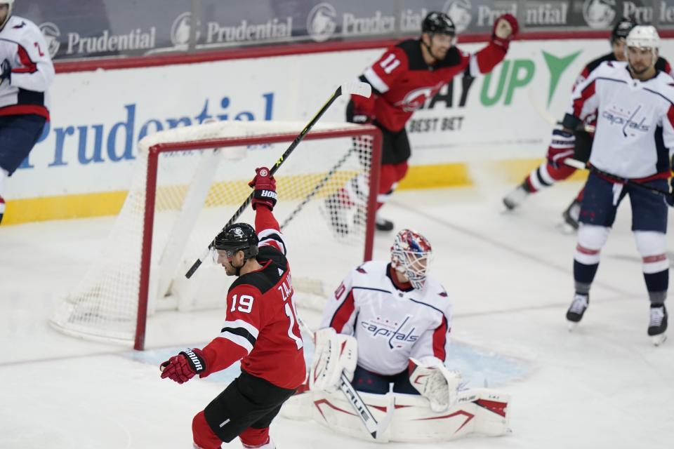 New Jersey Devils' Travis Zajac (19) celebrates as he skates past Washington Capitals goaltender Ilya Samsonov (30) after scoring a goal during the first period of an NHL hockey game Sunday, April 4, 2021, in Newark, N.J. (AP Photo/Frank Franklin II)