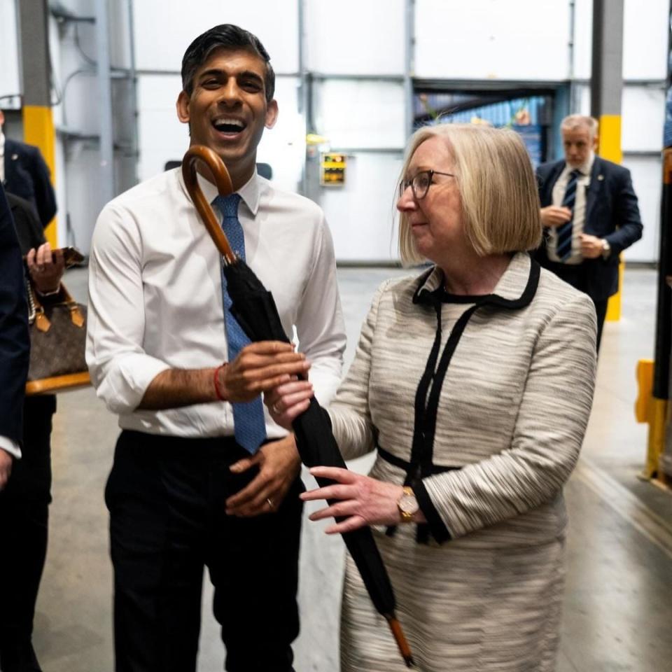 Maggie Throup, the Tory MP for Erewash, gives Rishi Sunak an umbrella as he visited Derbyshire this morning