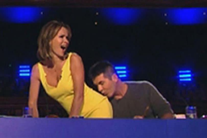 Simon Cowell kissing Amanda Holden's bum