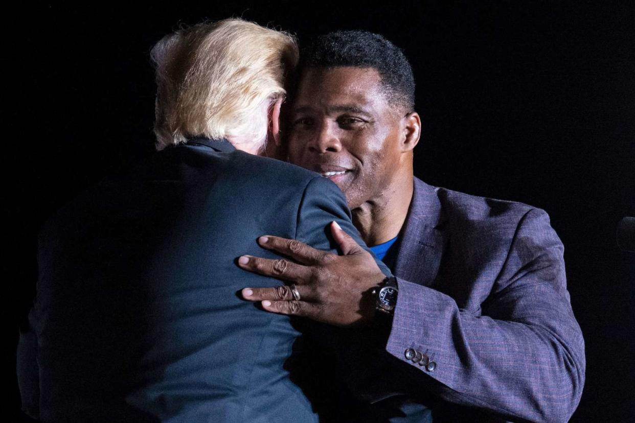 Former President Donald Trump hugs Georgia Senate candidate Herschel Walker during his Save America rally in Perry, Ga., on Saturday, Sept. 25, 2021.