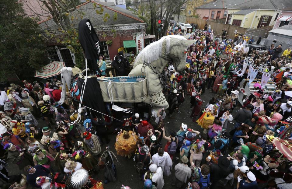 A trojan horse float makes its way through the crowd as revelers gather for the start of the Society of Saint Anne walking parade in the Bywater section of New Orleans during Mardi Gras day, Tuesday, Feb. 12, 2013.  Overcast skies and the threat of rain couldn't dampen the revelry of Mardi Gras as parades took to the streets, showering costumed merrymakers with trinkets of all kinds.  (AP Photo/Gerald Herbert)