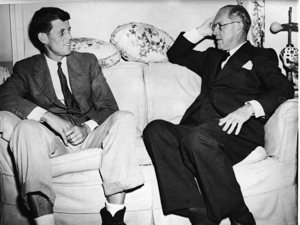 Joe Kennedy Sr. and John F. Kennedy are photographed sitting on a couch in 1938.