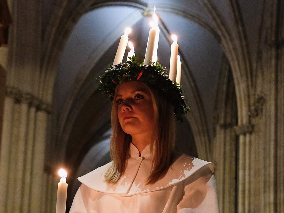 A young woman wearing the traditional lighted wreath of St. Lucia Day