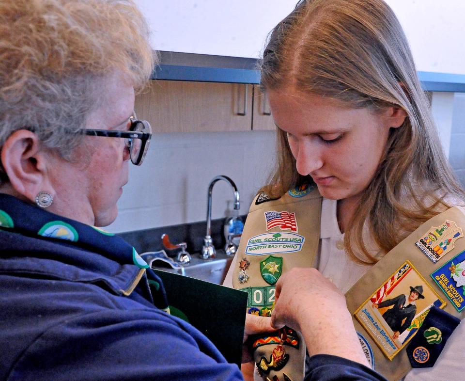 Elisha Snyder receives her Girl Scout medal from Jane Christyson for saving her mother's life. The medal is "given for saving a life or attempting to save a life without risk to the candidate's own life."