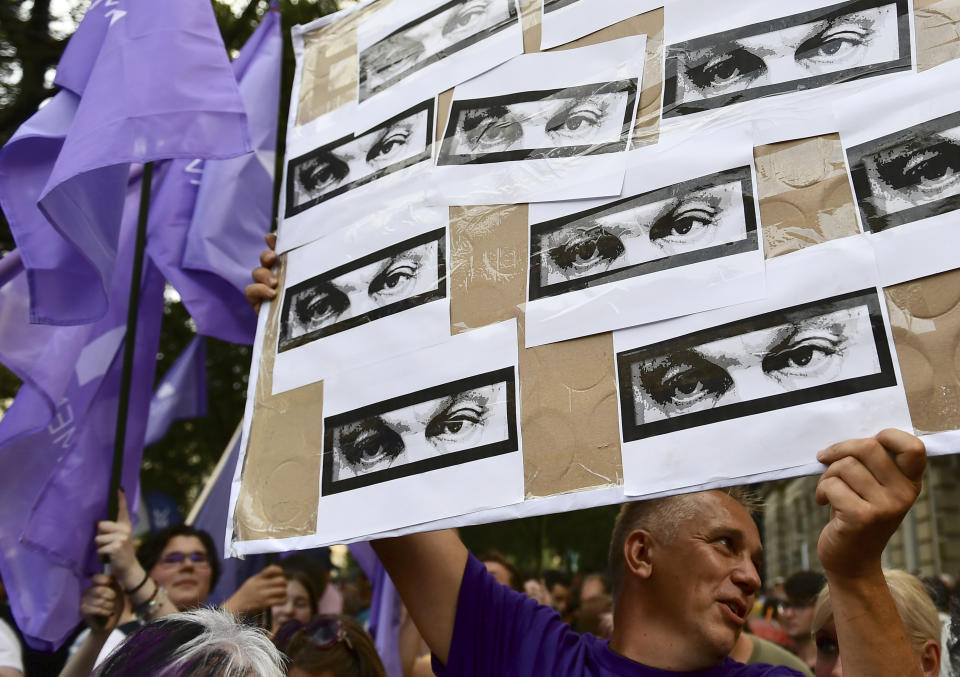 A man holds a banner shows eyes of Hungarian Prime Minister Viktor Orban during a protest against the government's alleged use of powerful spyware to spy on opponents, Budapest, Hungary, July 26, 2021. A report released more than a week ago by investigative journalists suggested the government used the software to monitor critical journalists, politicians and businesspeople through their smartphones. (AP Photo/Anna Szilagyi)