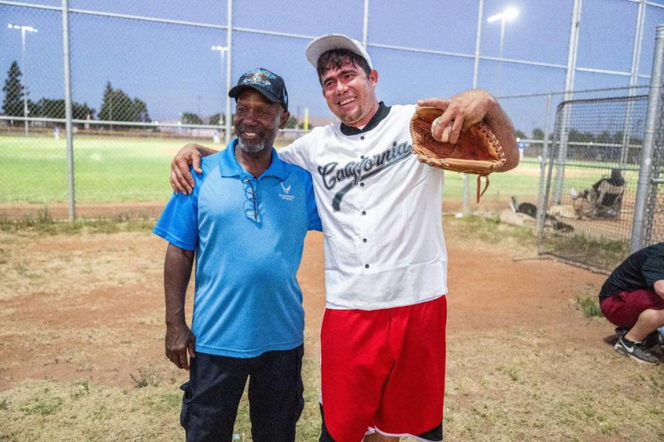 Dionisio Holmes stands with Jorge Gil Laguna, one of the immigrants that was flown to Sacramento last year, as he attends a tryout for the Sacramento Men’s Senior Baseball League earlier this month. Holmes, who was born in Panama, helped Laguna get placed on the team.
