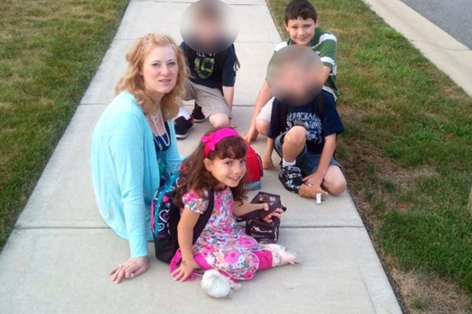 Kristine Barnett sitting on the sidewalk with her kids, including Natalia Grace