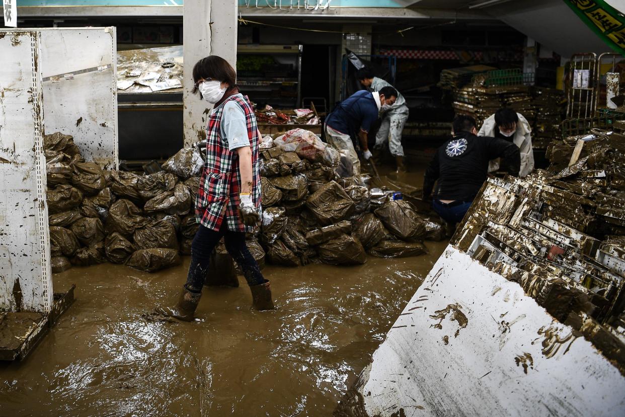 People clean up the mess in a supermarket following heavy rains and flooding in Hitoyoshi, Kumamoto prefecture, July 9, 2020. / Credit: CHARLY TRIBALLEAU/AFP/Getty