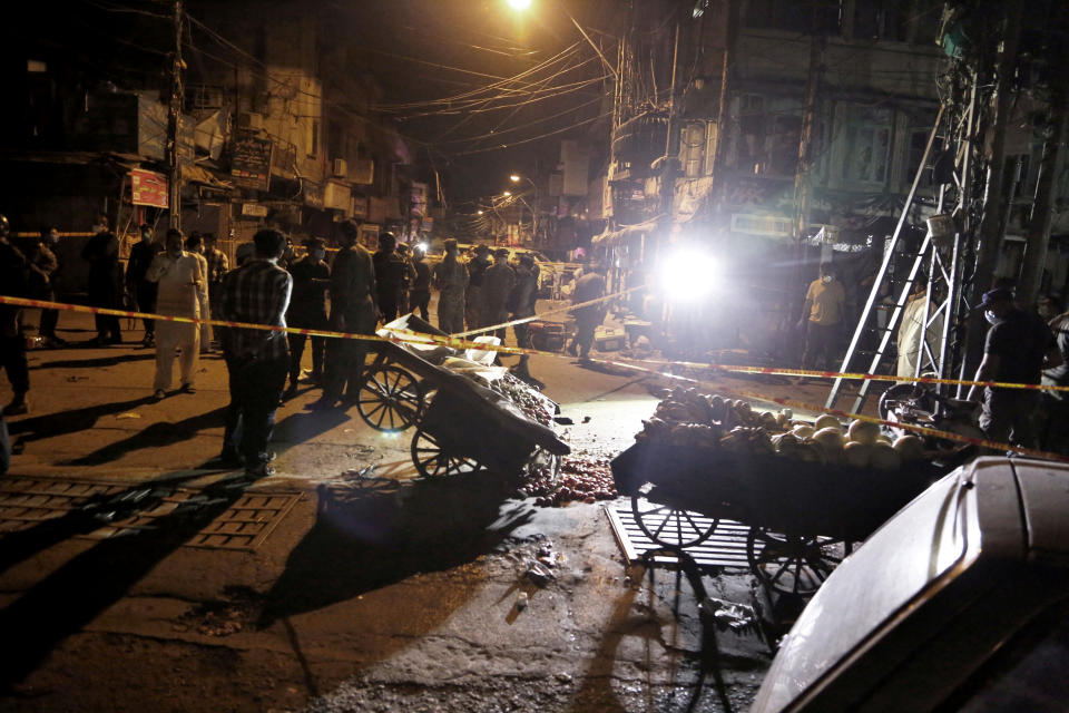 Pakistan's security officials examine the site of a bomb explosion that ripped through a bazaar in Rawalpindi, Pakistan, Friday, June 12, 2020.(AP Photo/A.H. Chaudary)