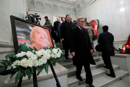 People walk past a picture of the founder of Russia's oldest human rights group and Sakharov Prize winner, Lyudmila Alexeyeva, during her memorial service in Moscow, Russia December 11, 2018. REUTERS/Maxim Shemetov