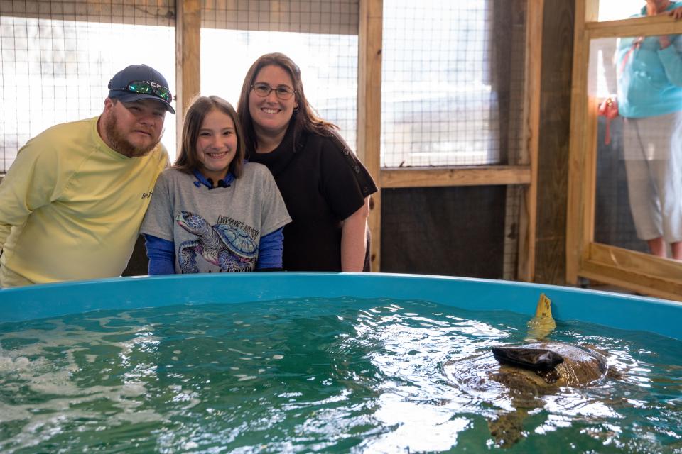 Kendall Barfield and her parents meet Bandit, a turtle at the Georgia Sea Turtle Center on Jekyll Island.