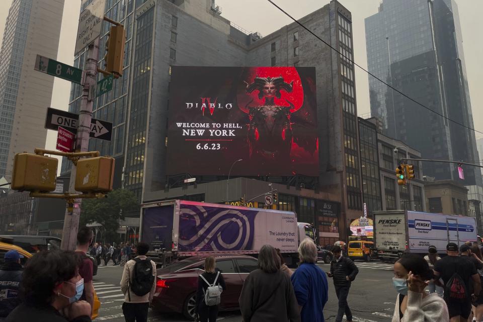 <p>Seen through a smokey haze from Canadian wildfires, a billboard displays an ad for Blizzard's Diablo IV on Wednesday, June 7, 2023, in New York. Smoke from Canadian wildfires poured into the U.S. East Coast and Midwest on Wednesday, covering the capitals of both nations in an unhealthy haze, holding up flights at major airports, postponing Major League Baseball games and prompting people to fish out pandemic-era face masks. (AP Photo/Andy Bao)</p> 