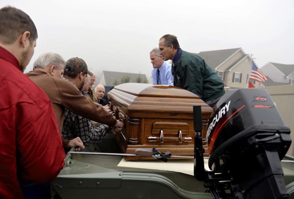 Pallbearers begin to lift the casket of Ronald "Manny" Bloss Sr., 78, from the flat-bottom jon boat that carried him from Diehl Funeral Home & Cremation Center in Mount Wolf to Manchester Union Cemetery on Wednesday, Jan. 15, 2014 in Manchester, Pa. Bloss died Saturday, Jan. 11, of terminal cancer. Per his wishes, the outdoorsman and Korean War veteran made his final journey via his jon boat _ in his casket _ from the funeral home to his burial plot. (AP Photo/York Daily Record, Chris Dunn) YORK DISPATCH OUT