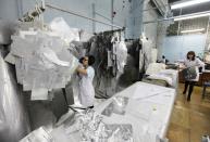 An employee selects aluminium templates for the production of multi-layered shield-vacuum thermal isolation items for space satellites at a workshop of the Reshetnev Information Satellite Systems company in the Siberian town of Zheleznogorsk April 1, 2014. Picture taken April 1, 2014. REUTERS/Ilya Naymushin (RUSSIA - Tags: SCIENCE TECHNOLOGY BUSINESS)