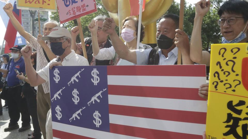 Protesters shout and hold posters outside the Taipei International Convention Center during the Taiwan-U.S. Defense Industry Forum in Taipei, Taiwan, on May 3, 2023. (Chiang Ying-ying/AP)