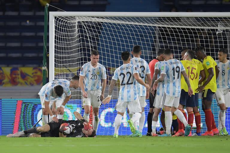 Dibu Martínez, en el piso, luego de una dura entrada de Yerry Mina, durante un partido de eliminatorias en 2021; el arquero salió lesionado