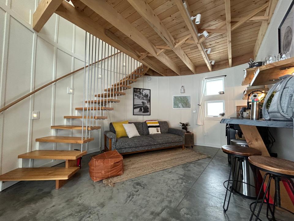 A living room with a couch next to a spiral staircase.