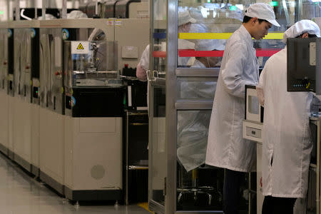 Employees work on a mobile phone production line at Huawei's factory campus in Dongguan, Guangdong province, China March 25, 2019. REUTERS/Tyrone Siu