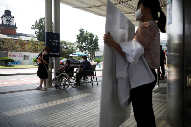 A doctor holds a sign to protest against a government plan to increase medical school admissions by 400 a year for the next decade to prepare for potential infectious disease outbreaks, at a hospital in Seoul