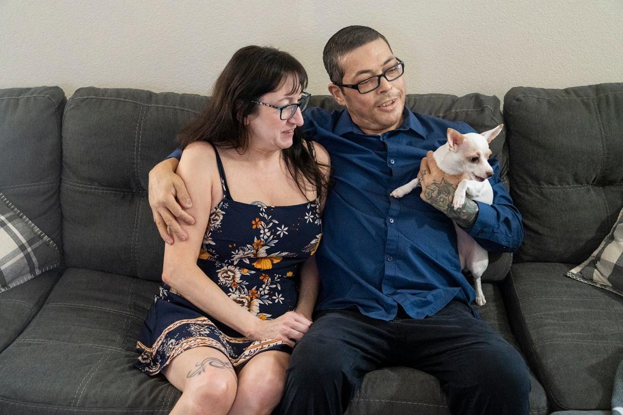 Charles and Nicole Richard play with their dogs in their home. Charles has stage 4 lung cancer.
