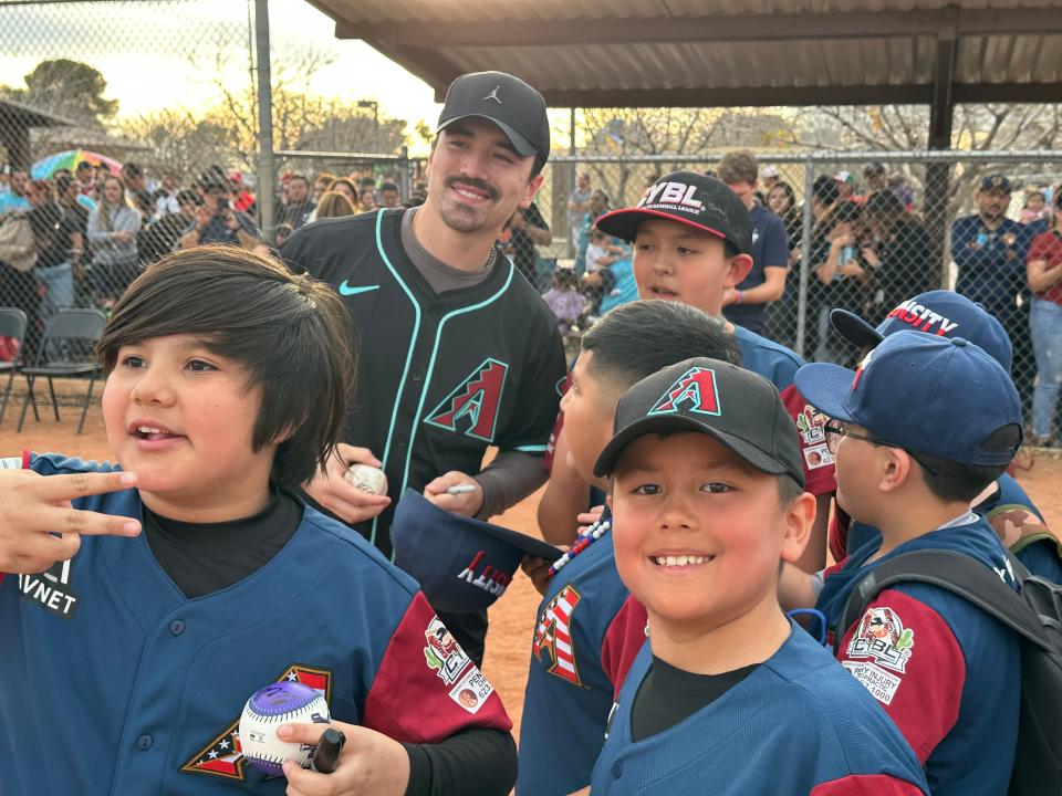 Members of a youth baseball team crowd around Diamondbacks star Corbin Carroll on Feb. 19, 2024, at Phoenix's El Oso Park.