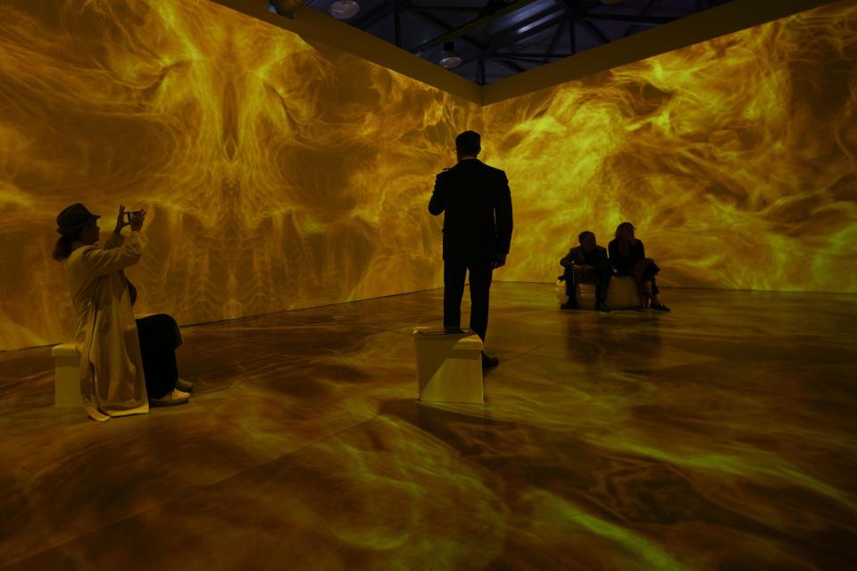 Visitors enjoy an installation at the opening of the art exhibition "Klimt - The Gold Experience". An immersive exhibition dedicated to the hypnotic and revolutionary work of Gustav Klimt who made the sensuality of gold his inimitable stylistic, at the Next Museum in Sesto San Giovanni, outskirt of Milan, Italy, Friday, Oct. 20, 2023. (AP Photo/Luca Bruno)