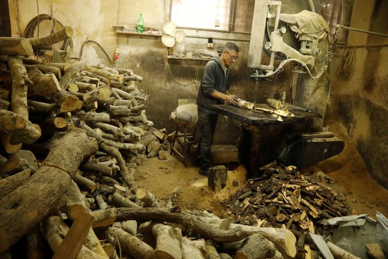 Palestinian worker uses olive wood to carve figurines for sale during Christmas season, at a workshop in Bethlehem in the Israeli-occupied West Bank