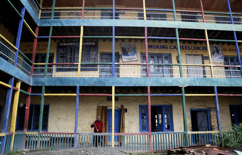 A Kashmiri man cleans the premises of a deserted school in Srinagar, Indian controlled Kashmir, Monday, Aug. 19, 2019. Restrictions continue in much of Indian-administered Kashmir, despite India's government saying it was gradually restoring phone lines and easing a security lockdown that's been in place for nearly two weeks. (AP Photo/Mukhtar Khan)