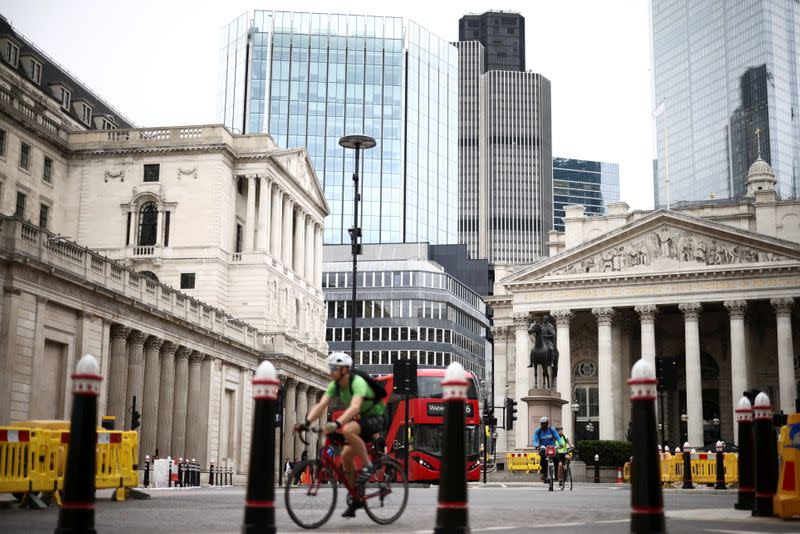 FILE PHOTO: The Bank of England can be seen as people cycle through the City of London financial district