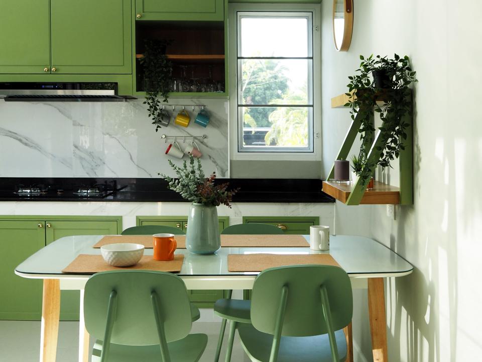 Kitchen with green chairs and cabinets