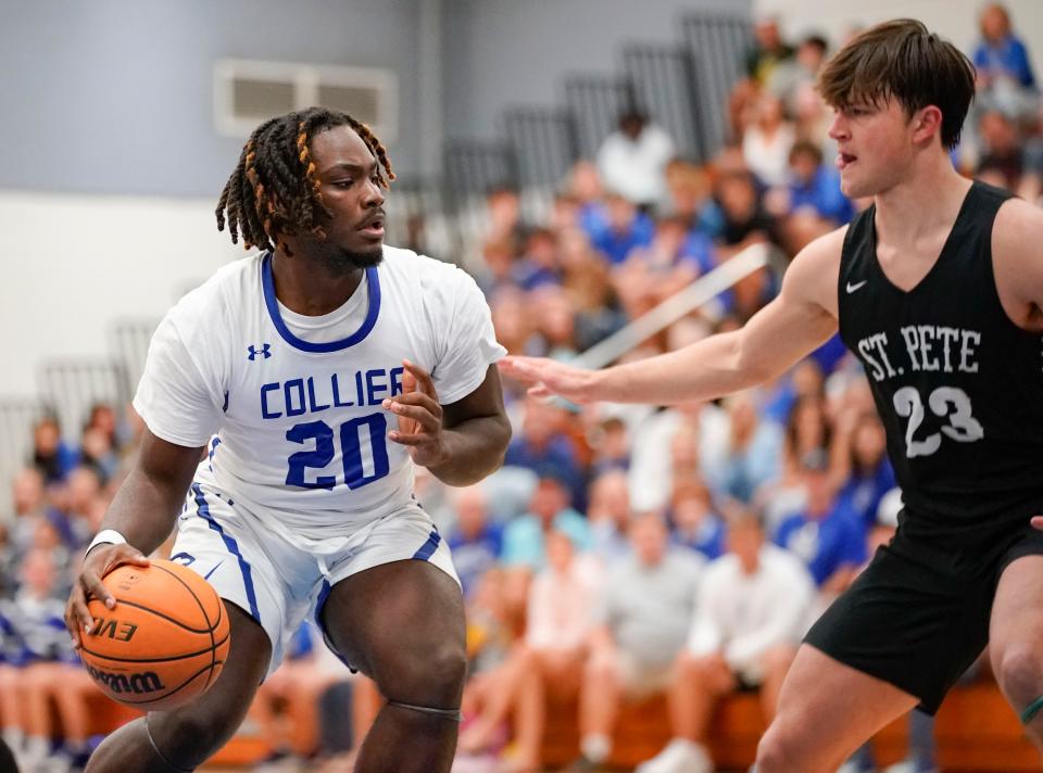 Barron Collier Cougars forward Joshua Henry (20) drives to the basket while being guarded by St. Petersburg Green Devils forward Dylan Kramer (23) during the first quarter of the Class 5A Region 3 finals at Barron Collier High School in Naples on Friday, Feb. 24, 2023.