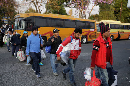 Central American migrants, part of a caravan moving through Mexico, queue to board a bus bound to Mexico City, in Puebla, Mexico April 9, 2018. REUTERS/Imelda Medina