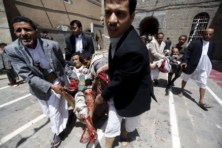 ATTENTION EDITORS - VISUAL COVERAGE OF SCENES OF INJURY OR DEATH People carry the injured out of a mosque which was attacked by a suicide bomber in Sanaa March 20, 2015. At least 16 people were killed when suicide bombers blew themselves up in two mosques in the Yemeni capital Sanaa on Friday during noon prayers, medical sources told Reuters. The mosques are known to be used mainly by supporters of the Shi'ite Muslim Houthi group which has seized control of the government. REUTERS/Khaled Abdullah TPX IMAGES OF THE DAY TEMPLATE OUT - RTR4U5R1