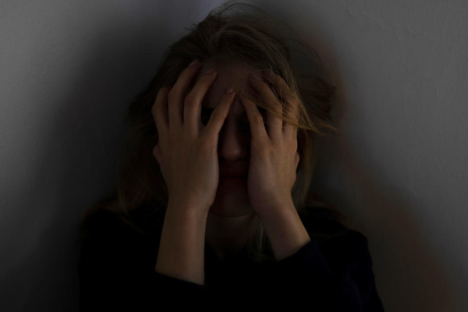 Woman covering her face with hands, appearing distressed or upset