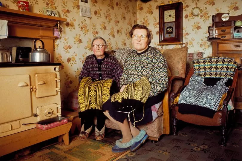 SHETLAND ISLANDS, SCOTLAND - 1st JUNE: Two elderly women knitting Fair Isle style jumpers pose in the living room of a cottage on one of the Shetland Islands in June 1970. (Photo by Chris Morphet/Redferns)