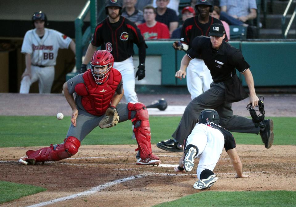 Rochester's Jimmy Kerrigan beats the throw ti Lehigh Valley catcher Matt McBride as home plate umpire Alex Tosi gets into position to make a call. 