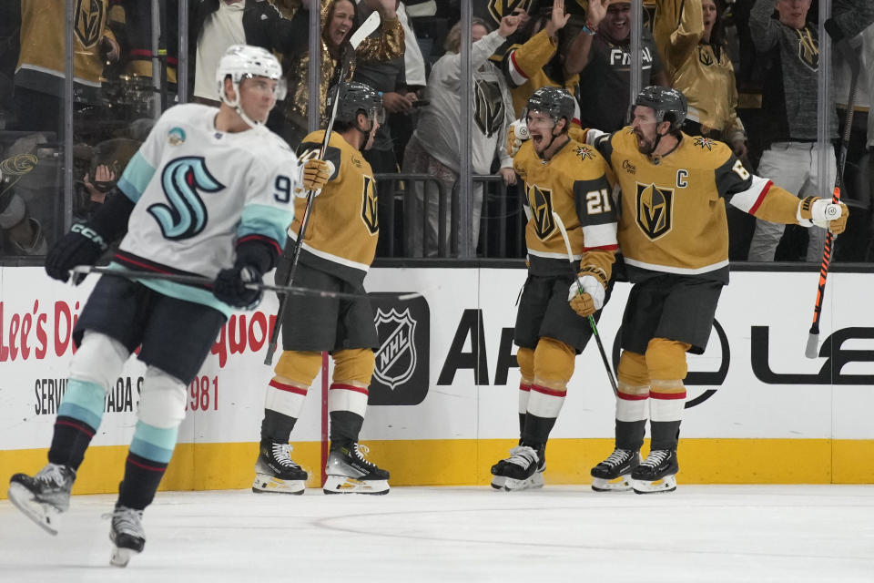 Vegas Golden Knights right wing Mark Stone, right, and center Brett Howden (21) celebrate after Vegas Golden Knights' Chandler Stephenson, third from right, scored against the Seattle Kraken during the first period of an NHL hockey game Tuesday, Oct. 10, 2023, in Las Vegas. (AP Photo/John Locher)