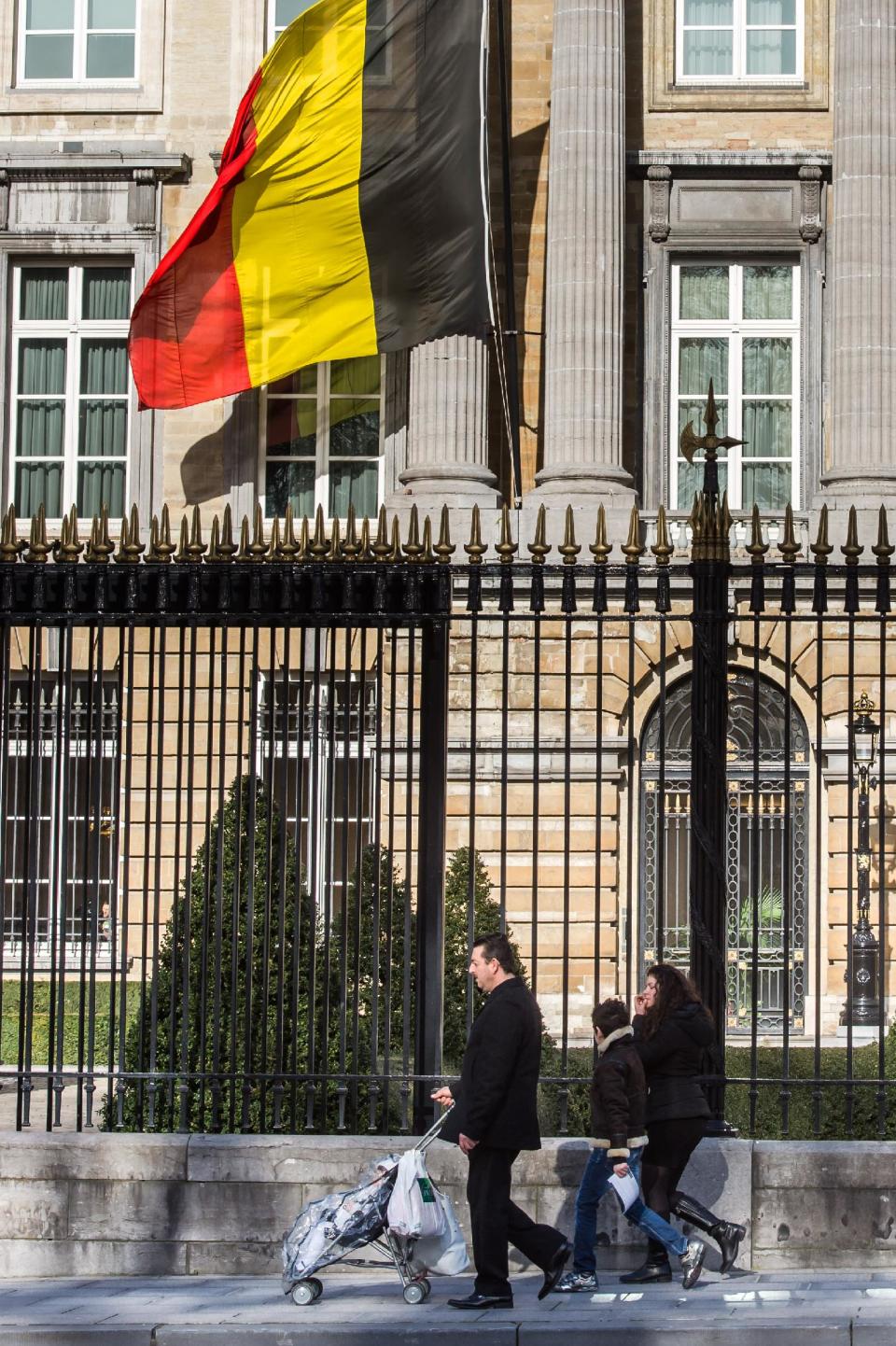 A couple with two children walk on the sidewalk in front of the Belgian federal parliament in Brussels, Wednesday Feb. 12, 2014. Belgium, one of the very few countries where euthanasia is legal, is expected to take the unprecedented step this week of abolishing age restrictions on who can ask to be put to death, extending the right to children. The legislation appears to have wide support in the largely liberal country. But it has also aroused intense opposition from foes, including a list of paediatricians, and everyday people who have staged street protests, fearing that vulnerable children will be talked into making a final, irreversible choice. (AP Photo/Geert Vanden Wijngaert)