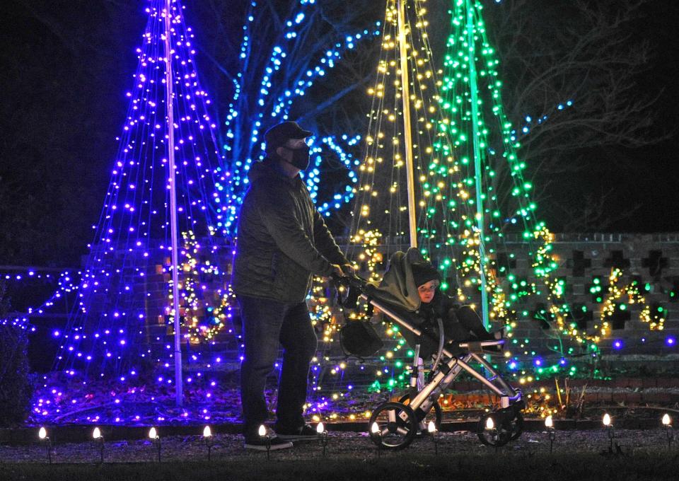 A youngster and his dad make their way along the Christmas lighted trails of the Bradley Estate in Canton during "Winterlights" in Canton, Tuesday, Dec. 1.